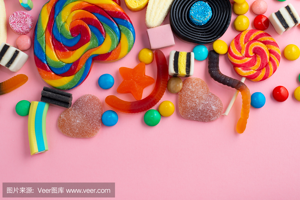 糖果和果凍彩色陣列不同的兒童糖果和糖果在粉紅色的背景與復制空間