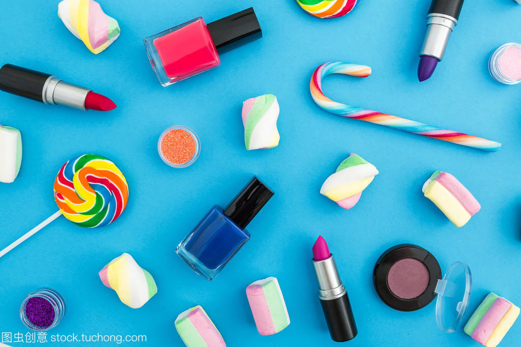 藍色背景下各種彩色糖果的化妝品產品